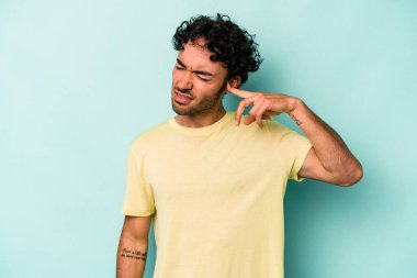 Beyaz arka planda izole edilmiş genç beyaz bir adam kulaklarını elleriyle kapatıyor..