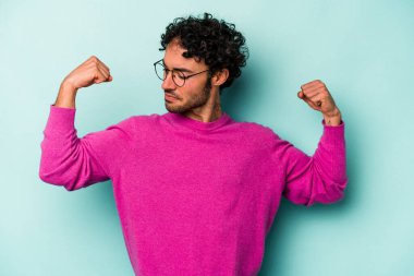 Beyaz arka planda izole edilmiş genç beyaz bir adam güçlü bir hareket gösteriyor, kollarıyla, kadınsı gücün sembolü.