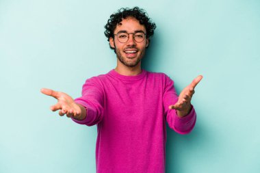 Beyaz arka planda izole edilmiş genç beyaz adam kameraya sarıldığı için kendinden emin hissediyor..