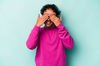 Beyaz arka planda izole edilmiş genç beyaz bir adam elleriyle gözlerini kapatmaktan korkuyor..