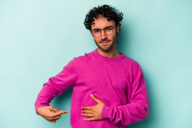 Beyaz arka planda karaciğer ağrısı çeken, karnı ağrıyan genç beyaz bir adam..