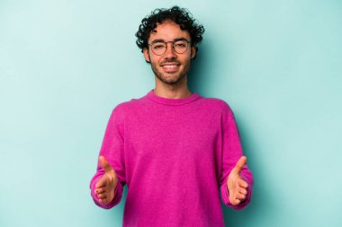 Beyaz arka planda izole edilmiş beyaz bir adam iki eliyle bir şey tutuyor..