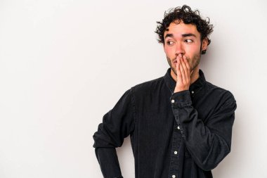 Beyaz arka planda izole edilmiş genç beyaz bir adam gizli bir sıcak fren haberi veriyor ve yana bakıyor.