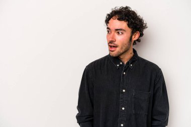 Beyaz arka planda izole edilmiş genç beyaz adam gördüğü bir şey yüzünden şoka uğruyor..