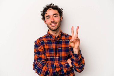 Beyaz arka planda izole edilmiş genç beyaz adam iki numarayı parmaklarıyla gösteriyor..