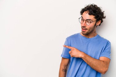 Beyaz arka planda izole genç beyaz adam parmak uzakta, gülüyor ve kaygısız.