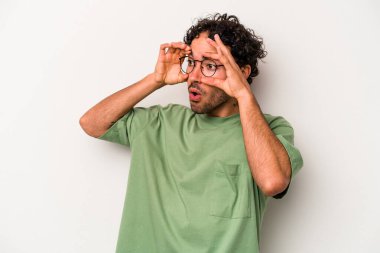 Beyaz arka planda izole edilmiş genç beyaz bir adam bir başarı fırsatı bulmak için gözlerini açık tutuyor..