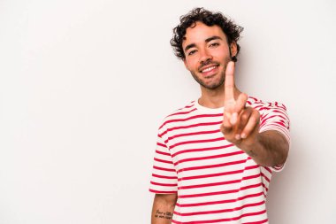 Beyaz arka planda izole edilmiş beyaz tenli genç bir adam bir numarayı parmağıyla gösteriyor..