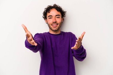 Beyaz arka planda izole edilmiş genç beyaz adam kameraya sarıldığı için kendinden emin hissediyor..