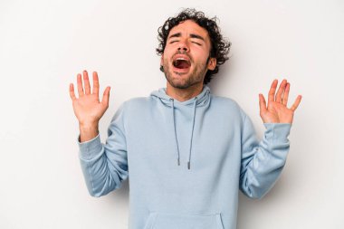 Beyaz arka planda izole edilmiş genç beyaz adam gökyüzüne haykırıyor, yukarı bakıyor, hayal kırıklığına uğramış..