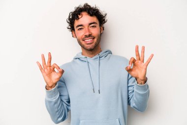 Beyaz arka planda izole edilmiş genç beyaz bir adam neşeli ve kendinden emin..