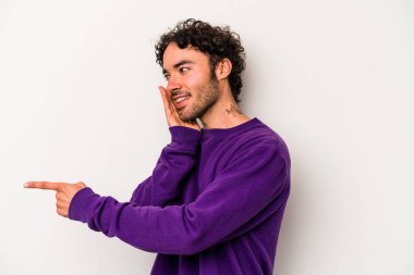 Beyaz arka planda izole edilmiş genç beyaz bir adam bir dedikodu söylüyor, bir haber sunuyor..