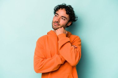 Beyaz arka planda soyutlanmış genç beyaz bir adam düşünüyor ve yukarı bakıyor, yansıtıyor, düşünüyor, hayal kuruyor..