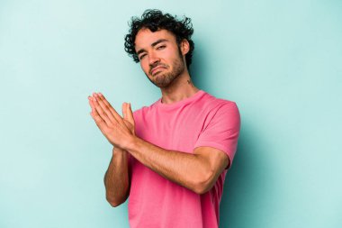 Beyaz arka planda izole olmuş genç beyaz bir adam enerjik ve rahat hissediyor, ellerini ovuşturuyor..