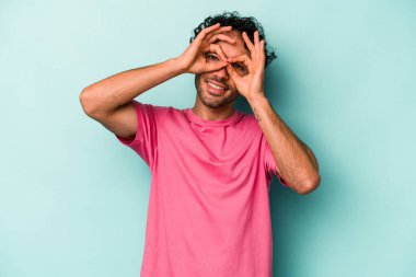 Beyaz arka planda izole edilmiş genç beyaz bir adam gözlerinde sorun olmadığını gösteriyor.