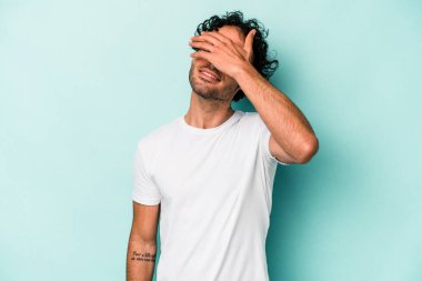 Beyaz arka planda izole olmuş genç beyaz bir adam ellerini başının üstünde tutarak neşeyle gülüyor. Mutluluk kavramı.