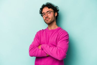 Beyaz arka planda izole edilmiş genç beyaz adam alaycı bir ifadeyle kameraya bakıyor..