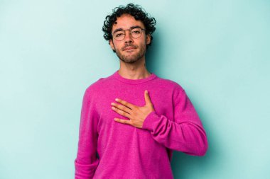 Beyaz arka planda izole edilmiş genç beyaz adam yemin ediyor, elini göğsüne koyuyor..