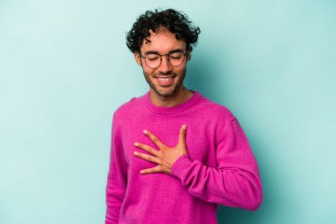 Beyaz arka planda izole genç beyaz adam yüksek sesle gülüyor elini göğsüne koyuyor..