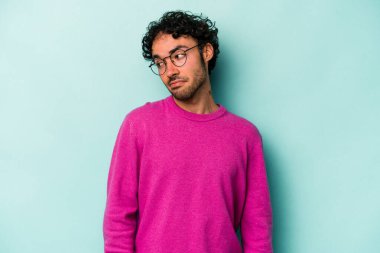 Beyaz arka planda izole edilmiş genç beyaz bir adam omuz silkiyor ve gözleri açık..