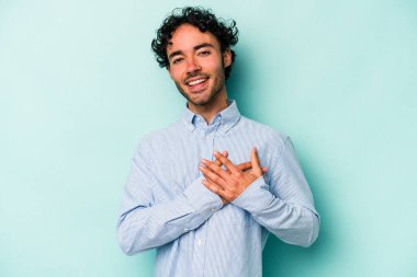 Beyaz arka planda izole edilmiş beyaz tenli genç bir adam, dostane bir ifadeye sahip, avuçlarını göğsüne bastırıyor. Aşk konsepti.