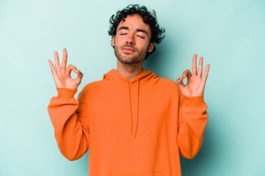 Beyaz arka planda izole edilmiş genç beyaz adam yoğun bir günün ardından rahatlıyor. Yoga yapıyor..