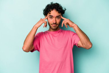 Beyaz arka planda izole edilmiş genç beyaz bir adam bir göreve odaklanmış, işaret parmaklarını işaret ediyor..