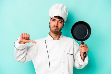 Mavi arka planda uçan tepsiyi tutan Kafkasyalı genç şef gururlu ve kendinden emin hissediyor, örnek olarak..