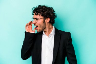 Kafkasyalı genç iş adamı mavi arka planda izole edilmiş bağırıyor ve avuç içini açık tutuyor..