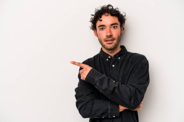 Beyaz arka planda izole edilmiş genç beyaz adam yan tarafı işaret ediyor