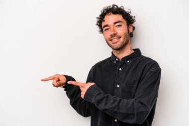 Beyaz arka planda izole edilmiş genç beyaz bir adam işaret parmağıyla işaret ettiği için heyecanlı..
