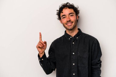 Beyaz arka planda izole edilmiş beyaz tenli genç bir adam bir numarayı parmağıyla gösteriyor..