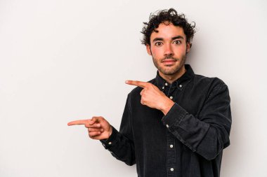 Beyaz arka planda izole edilmiş genç beyaz bir adam işaret parmağıyla fotokopi alanını işaret ederek şok oldu..