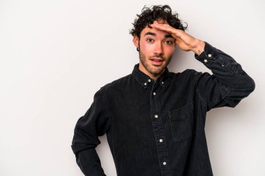 Beyaz arka planda izole genç beyaz adam yüksek sesle bağırıyor, gözleri açık ve elleri gergin tutuyor..