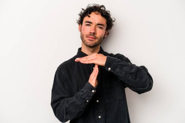 Beyaz arka planda izole edilmiş genç beyaz bir adam bir mola hareketi gösteriyor..