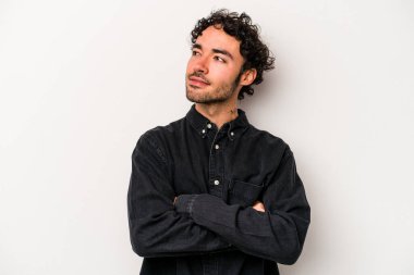 Beyaz arka planda izole edilmiş genç beyaz adam hedeflere ve amaçlara ulaşmayı hayal ediyor.