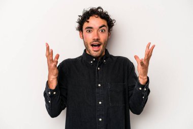 Beyaz arka planda izole edilmiş genç beyaz adam gökyüzüne haykırıyor, yukarı bakıyor, hayal kırıklığına uğramış..