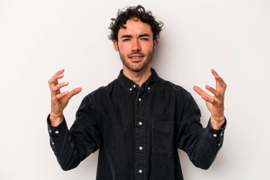 Beyaz arka planda izole edilmiş genç beyaz bir adam öfkeyle bağırıyor..