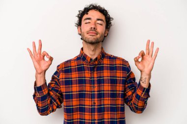 Beyaz arka planda izole edilmiş genç beyaz adam yoğun bir günün ardından rahatlıyor. Yoga yapıyor..