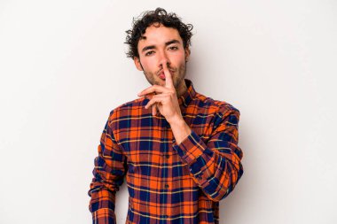 Beyaz arka planda izole edilmiş genç beyaz bir adam ya sır saklıyor ya da sessizlik istiyor..