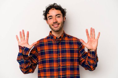 Beyaz arka planda izole edilmiş beyaz tenli genç adam on numarayı elleriyle gösteriyor..