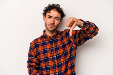 Beyaz arka planda izole edilmiş genç beyaz adam baş parmağını aşağı gösteriyor, hayal kırıklığı konsepti..