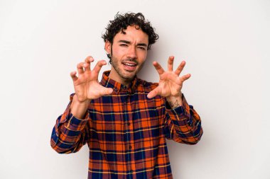 Beyaz arka planda izole edilmiş genç beyaz bir adam pençelerini kedi taklidi yaparken gösteriyor, agresif bir hareket..