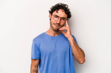 Beyaz arka planda izole edilmiş genç beyaz bir adam şakağı parmağıyla işaret ediyor, düşünüyor ve bir göreve odaklanıyor..