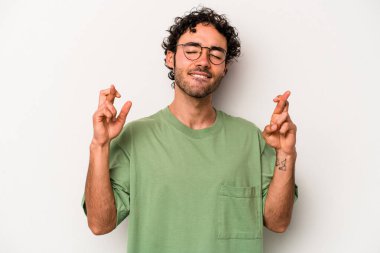 Beyaz arka planda izole genç beyaz adam şans dilemek için şans diliyor.