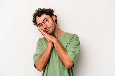 Beyaz arka planda izole edilmiş genç beyaz adam esniyor. Ağzı eliyle kapatan yorgun bir hareket sergiliyor..