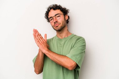 Beyaz arka planda izole olmuş genç beyaz bir adam enerjik ve rahat hissediyor, ellerini ovuşturuyor..