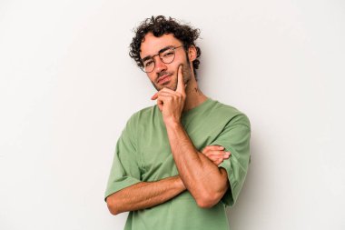 Beyaz arka planda izole edilmiş genç beyaz adam alaycı bir ifadeyle kameraya bakıyor..