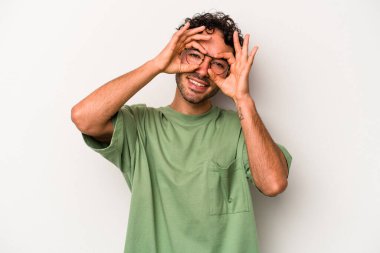 Beyaz arka planda izole edilmiş genç beyaz bir adam gözlerinde sorun olmadığını gösteriyor.