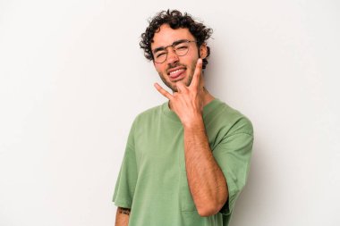 Beyaz arka planda izole edilmiş genç beyaz bir adam parmaklarıyla kaya hareketi gösteriyor.